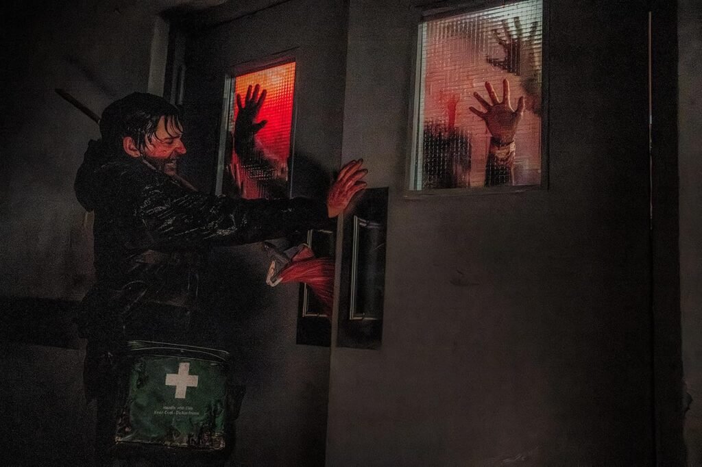 Austin Abrams em cena de fuga de zumbis no reboot de Resident Evil