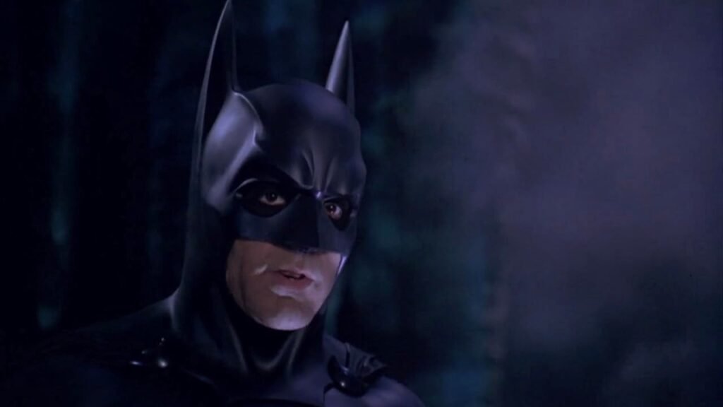 Batman em close diante de luzes coloridas em cena de Batman & Robin